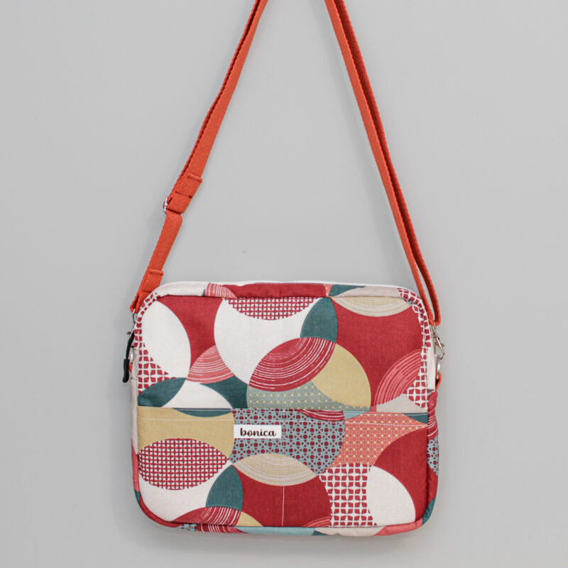 Bolso bandolera mujer en colores rojos y burdeos, con estampado geométrico