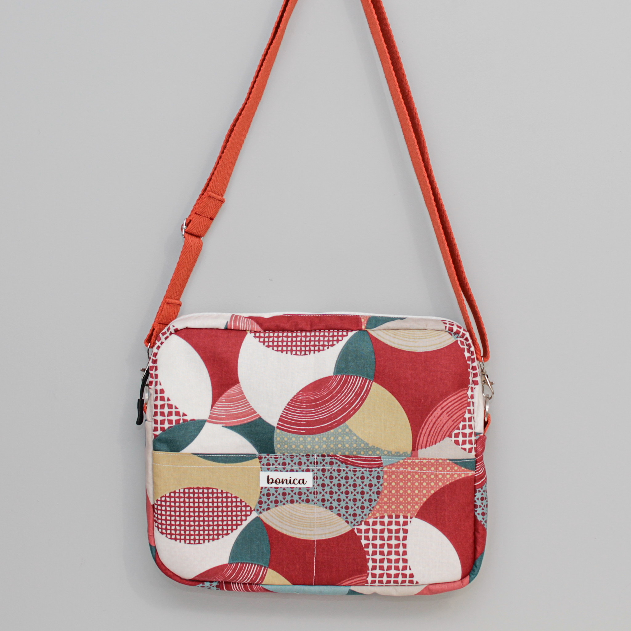 Bolso bandolera mujer en colores rojos y burdeos, con estampado geométrico